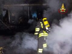 Casette di legno a fuoco nella notte a Bagno