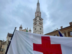 Il vessillo della Croce Rossa sventola sul balcone del Palazzo comunale di Modena